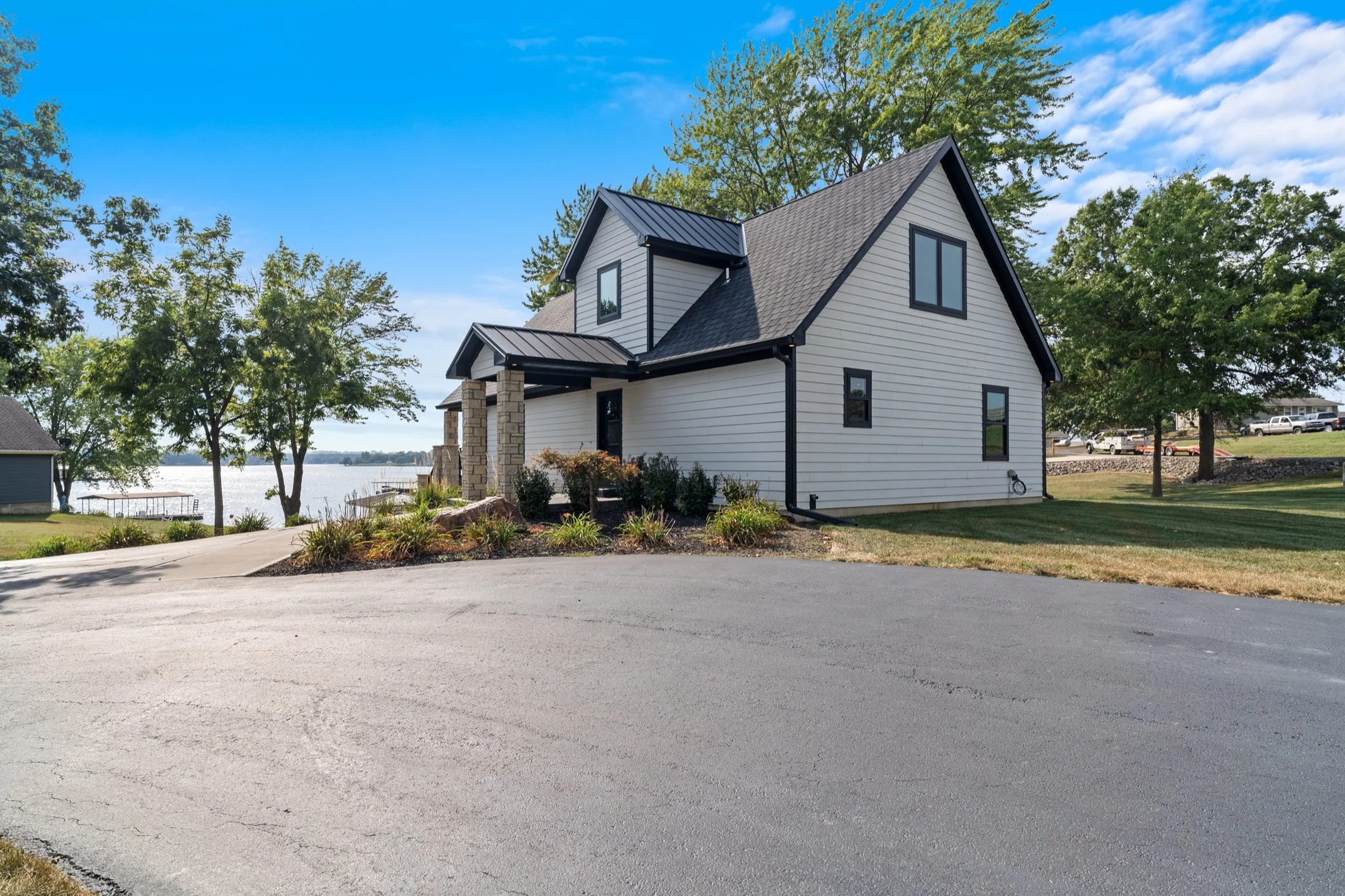 Modern lakeside home with a broad roofline, light siding and a tree-lined setting at 102 Angler Point.