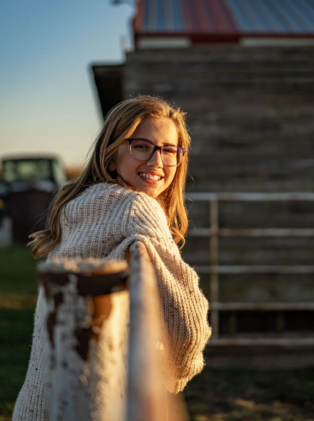 Outdoor portrait beside a wooden fence.